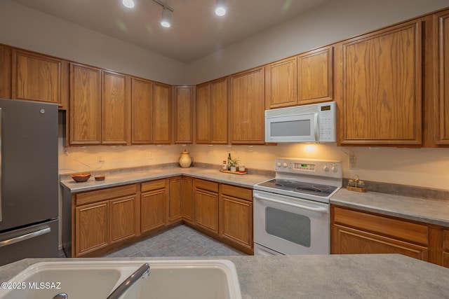 8191 N White Stallion Pl, Tucson, AZ 85743 - kitchen featuring white appliances and brown cabinetry