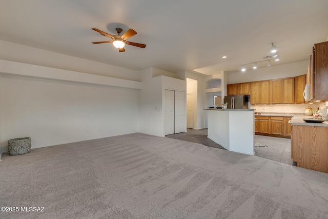8191 N White Stallion Pl, Tucson, AZ 85743 - kitchen with freestanding refrigerator, a ceiling fan, light colored carpet, open floor plan, and a center island