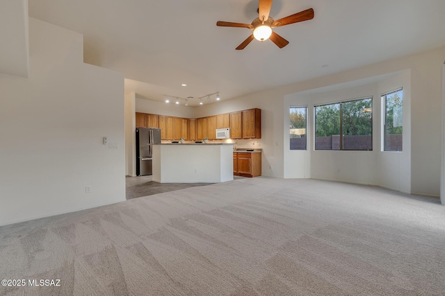 8191 N White Stallion Pl, Tucson, AZ 85743 - unfurnished living room featuring light carpet, a ceiling fan, and rail lighting