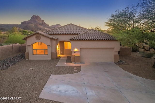 8191 N White Stallion Pl, Tucson, AZ 85743 - mediterranean / spanish-style home featuring stucco siding, an attached garage, driveway, and a tiled roof