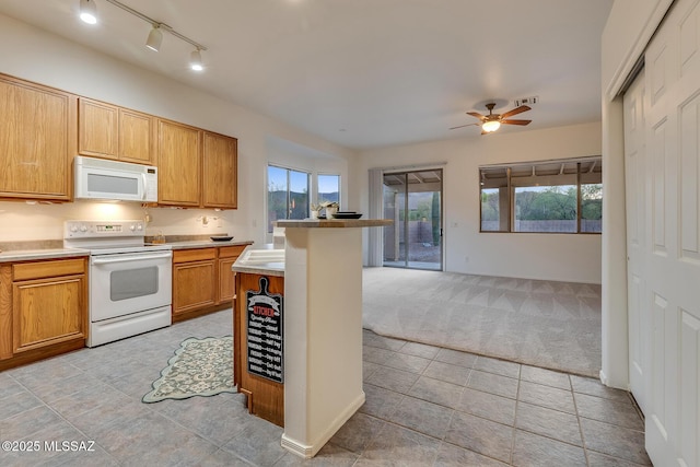 8191 N White Stallion Pl, Tucson, AZ 85743 - kitchen with white appliances, light carpet, a ceiling fan, light tile patterned floors, and open floor plan