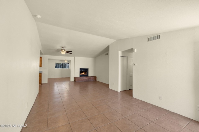 2520 W Vereda De Las Flores, Tucson, AZ 85746 - unfurnished living room with light tile patterned flooring, a brick fireplace, vaulted ceiling, and ceiling fan