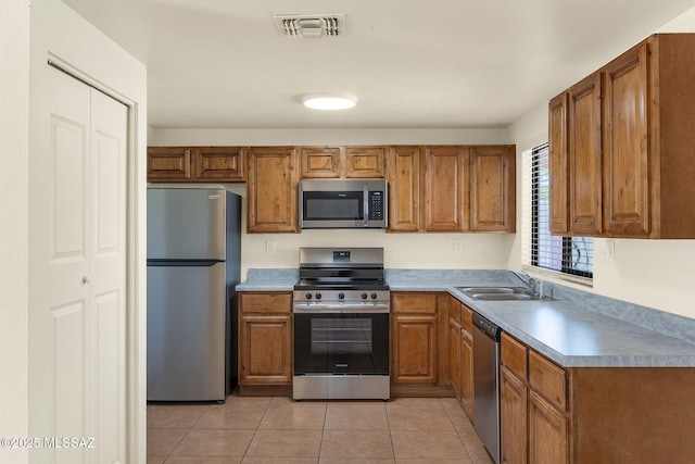 2520 W Vereda De Las Flores, Tucson, AZ 85746 - kitchen with stainless steel appliances, brown cabinets, and light tile patterned floors