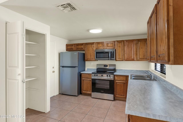 2520 W Vereda De Las Flores, Tucson, AZ 85746 - kitchen with stainless steel appliances, brown cabinetry, light tile patterned floors, and light countertops
