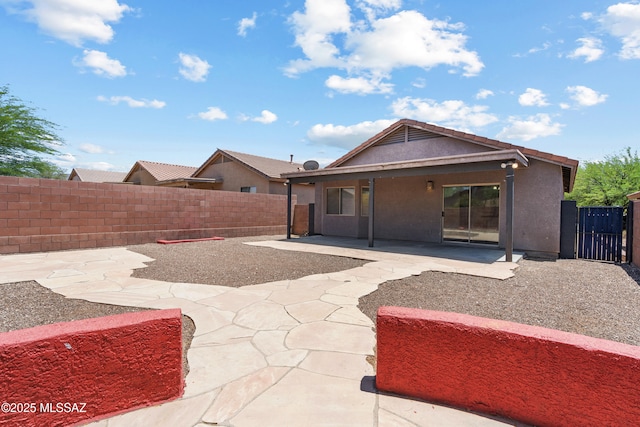 9969 E Apache Rain Dr, Tucson, AZ 85748 - rear view of house featuring a fenced backyard, a patio, stucco siding, and a gate