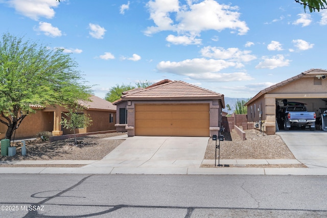 9969 E Apache Rain Dr, Tucson, AZ 85748 - view of front of property featuring stucco siding, driveway, and a tile roof