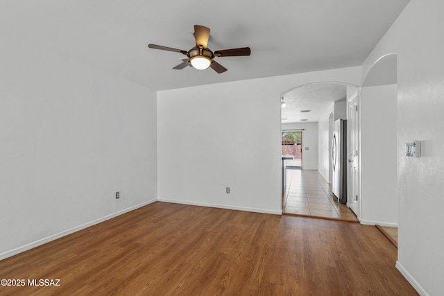 9969 E Apache Rain Dr, Tucson, AZ 85748 - spare room with arched walkways, a ceiling fan, and wood finished floors
