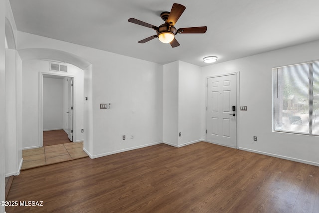 9969 E Apache Rain Dr, Tucson, AZ 85748 - unfurnished room featuring arched walkways, a ceiling fan, and wood finished floors