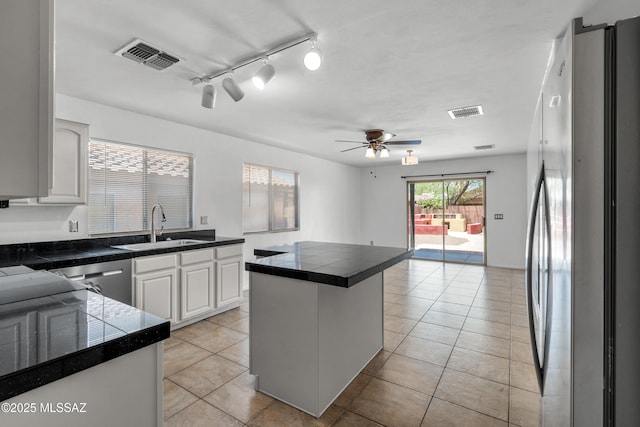 9969 E Apache Rain Dr, Tucson, AZ 85748 - kitchen featuring appliances with stainless steel finishes, light tile patterned floors, ceiling fan, and white cabinetry