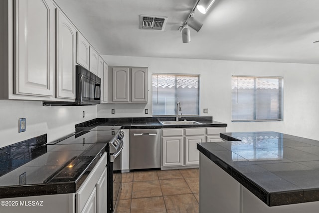 9969 E Apache Rain Dr, Tucson, AZ 85748 - kitchen with stainless steel appliances, tile countertops, track lighting, tile patterned flooring, and ceiling fan