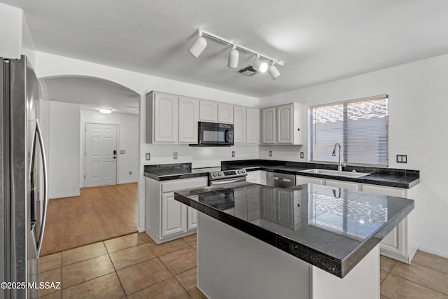9969 E Apache Rain Dr, Tucson, AZ 85748 - kitchen featuring stainless steel appliances, tile countertops, arched walkways, white cabinetry, and light tile patterned floors