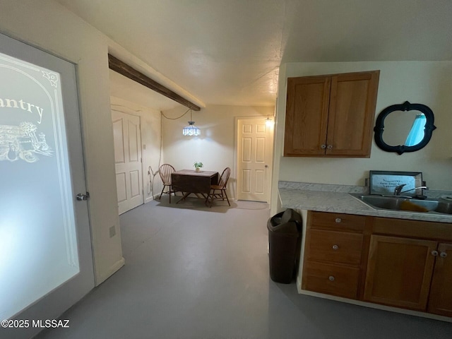 1094 N Pomerene Rd, Benson, AZ 85602 - kitchen with a sink, brown cabinetry, light countertops, and finished concrete floors