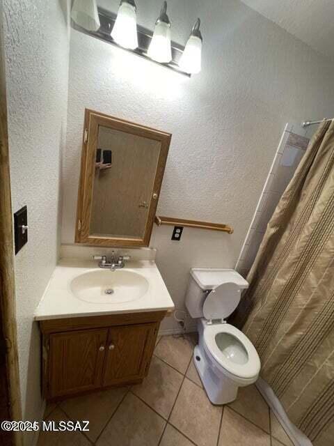 1094 N Pomerene Rd, Benson, AZ 85602 - bathroom with vanity, tile patterned floors, toilet, a shower with shower curtain, and a textured wall