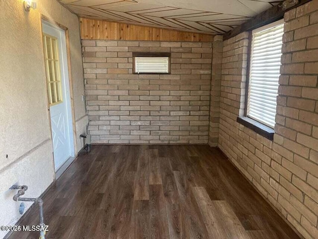 1094 N Pomerene Rd, Benson, AZ 85602 - empty room with brick wall and dark wood-type flooring
