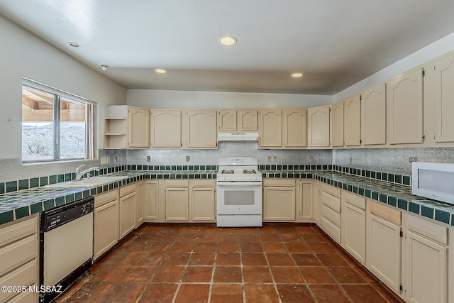 1503 Camino Bacalao, Rio Rico, AZ 85648 - kitchen featuring white appliances, tile counters, under cabinet range hood, decorative backsplash, and cream cabinetry