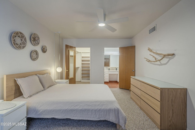 3940 E Timrod St Unit 226, Tucson, AZ 85711 - bedroom with light carpet, a walk in closet, a ceiling fan, and ensuite bathroom