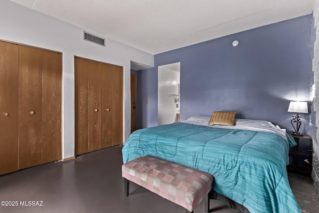7777 E Golf Links Rd Unit 2105, Tucson, AZ 85730 - bedroom featuring two closets, finished concrete flooring, and a textured ceiling