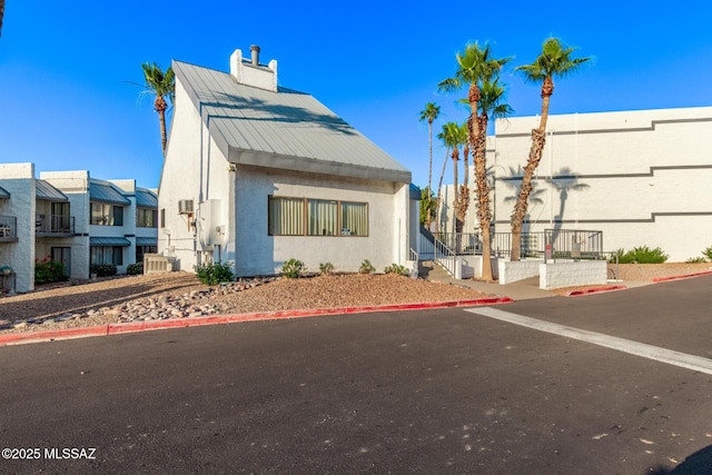 7777 E Golf Links Rd Unit 2105, Tucson, AZ 85730 - view of front of property featuring stucco siding, a chimney, and a metal roof