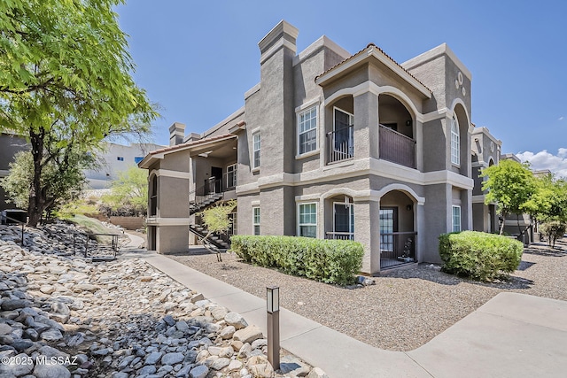 1500 E Pusch Wilderness Dr Unit 15205, Oro Valley, AZ 85737 - view of front of home featuring a balcony, a chimney, and stucco siding