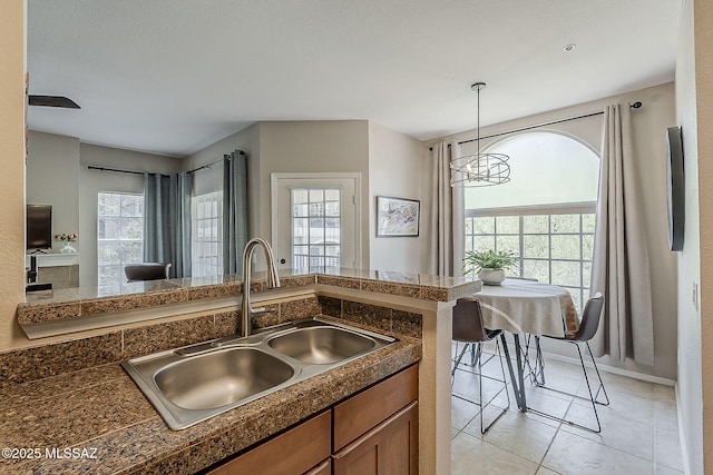 1500 E Pusch Wilderness Dr Unit 15205, Oro Valley, AZ 85737 - kitchen with tile counters, brown cabinetry, a chandelier, and decorative light fixtures