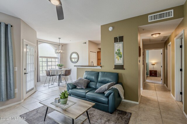 1500 E Pusch Wilderness Dr Unit 15205, Oro Valley, AZ 85737 - living area featuring light tile patterned floors, ceiling fan, and a chandelier