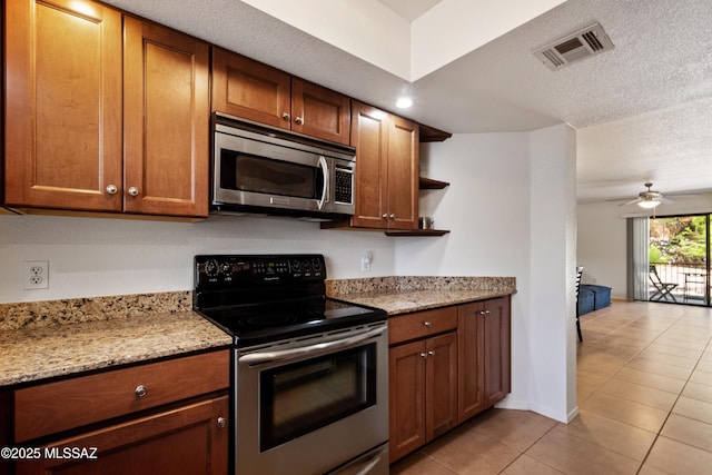 7255 E Snyder Rd Unit 9103, Tucson, AZ 85750 - kitchen featuring stainless steel appliances, light tile patterned flooring, a ceiling fan, open shelves, and brown cabinets