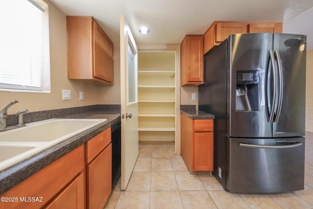 1641 S San Carla, Green Valley, AZ 85614 - kitchen featuring stainless steel refrigerator with ice dispenser, dark countertops, light tile patterned flooring, and brown cabinets