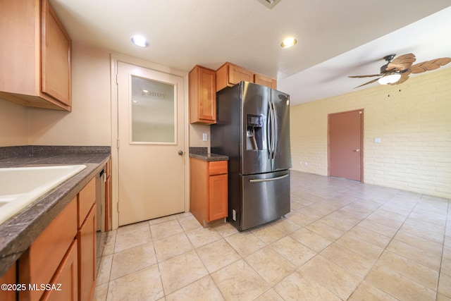 1641 S San Carla, Green Valley, AZ 85614 - kitchen with stainless steel fridge, brick wall, dark countertops, a ceiling fan, and light tile patterned floors