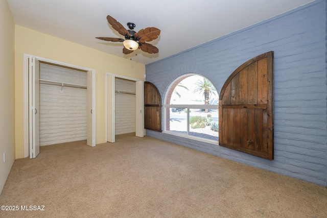 1641 S San Carla, Green Valley, AZ 85614 - unfurnished bedroom featuring brick wall, carpet, multiple closets, and a ceiling fan