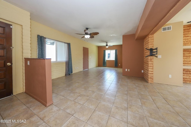 1641 S San Carla, Green Valley, AZ 85614 - unfurnished living room with a ceiling fan, brick wall, and light tile patterned flooring