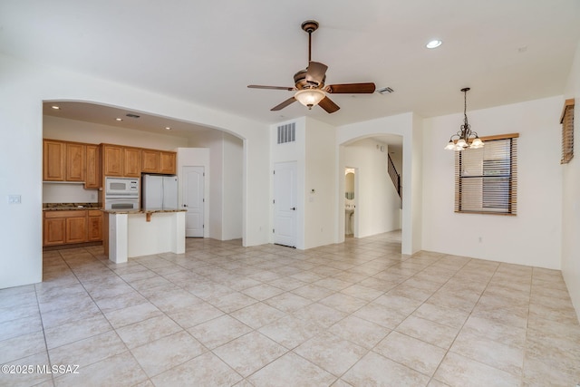 139 E Castlefield Cir, Tucson, AZ 85704 - unfurnished living room featuring arched walkways, ceiling fan, a chandelier, recessed lighting, and light tile patterned floors