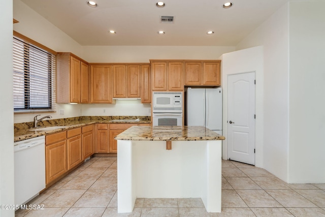 139 E Castlefield Cir, Tucson, AZ 85704 - kitchen featuring white appliances, a center island, light stone countertops, light tile patterned floors, and recessed lighting