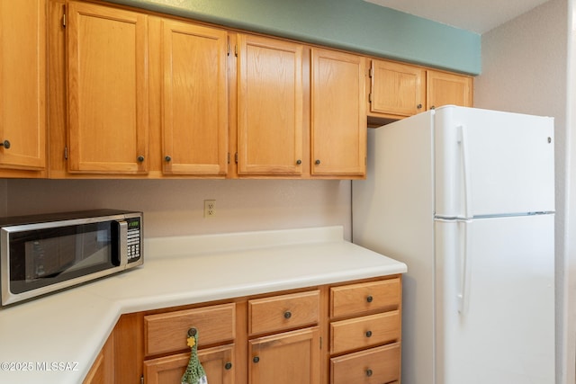 1857 W Dalehaven Cir, Tucson, AZ 85704 - kitchen with stainless steel microwave, freestanding refrigerator, light countertops, and light brown cabinets