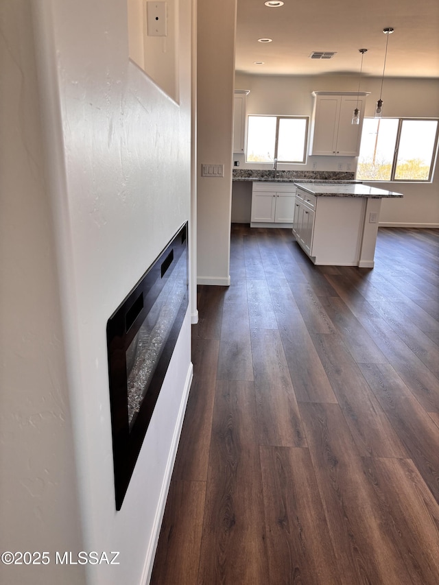 3152 E Andrada Rd, Vail, AZ 85641 - kitchen with dark wood-style flooring, pendant lighting, a kitchen island, stone counters, and backsplash