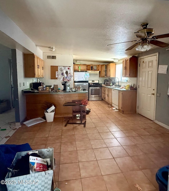 641 W Teton St, Tucson, AZ 85756 - kitchen with appliances with stainless steel finishes, a peninsula, light tile patterned flooring, ceiling fan, and a textured ceiling