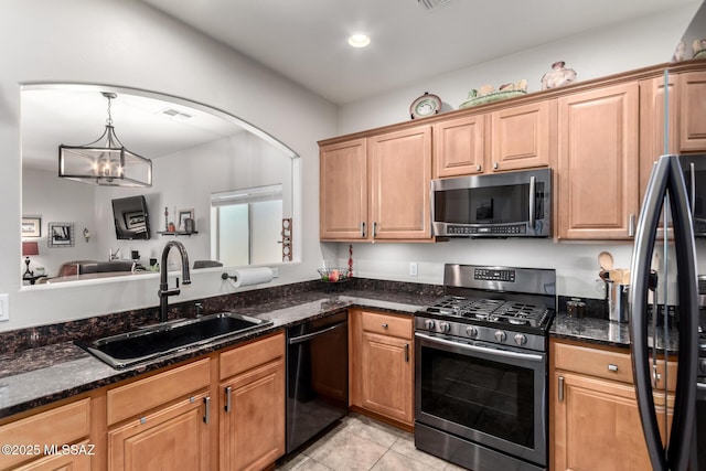 2257 E Skipping Rock Way, Tucson, AZ 85737 - kitchen with appliances with stainless steel finishes, a chandelier, dark stone countertops, light tile patterned floors, and decorative light fixtures