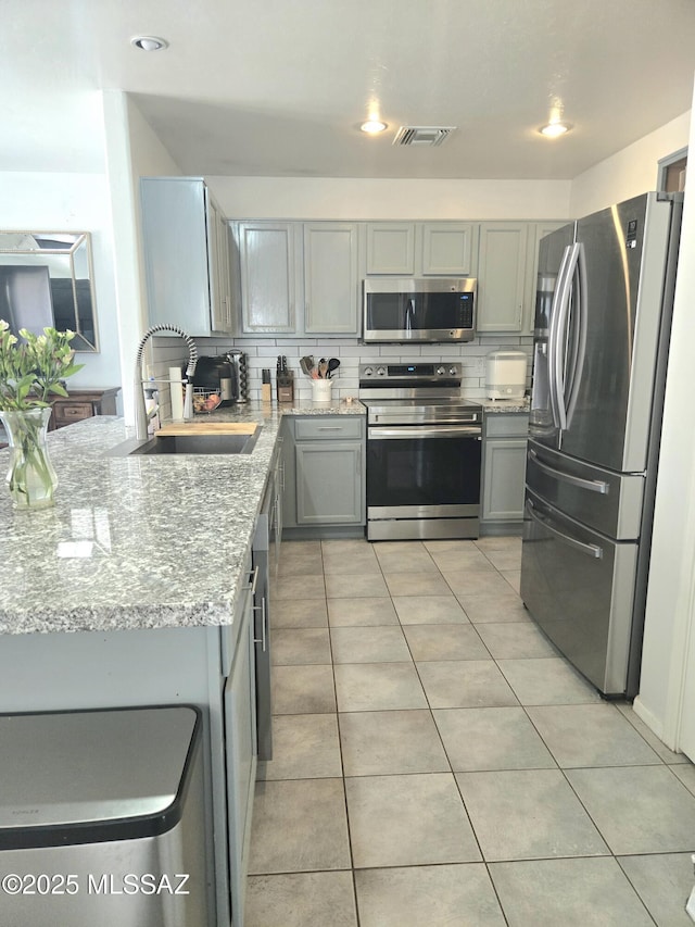 4295 W Banner Mine Pl, Tucson, AZ 85745 - kitchen with appliances with stainless steel finishes, light stone countertops, gray cabinets, and light tile patterned floors