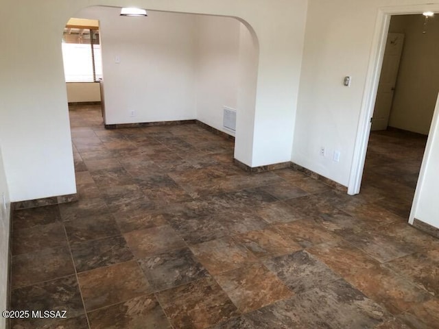 1048 E 7th St, Tucson, AZ 85719 - empty room with arched walkways and stone finish flooring