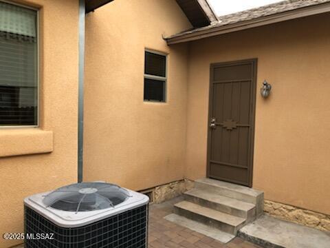 1048 E 7th St, Tucson, AZ 85719 - view of exterior entry with stucco siding and a patio area