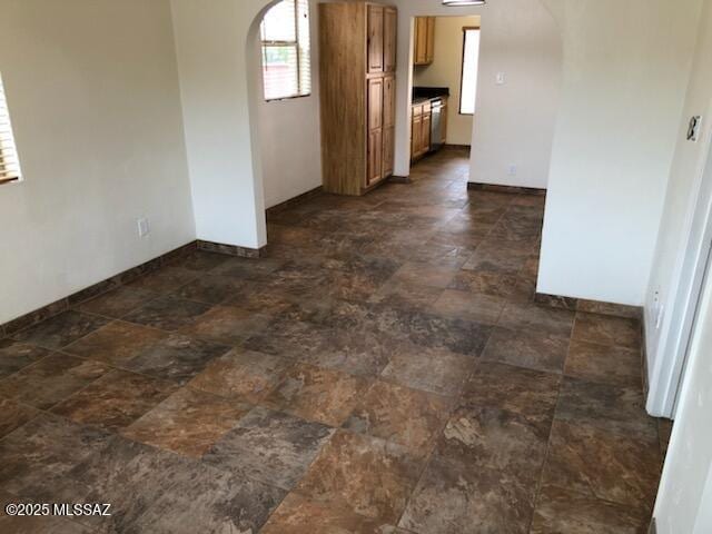 1048 E 7th St, Tucson, AZ 85719 - empty room featuring arched walkways and stone finish flooring