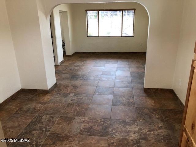 1048 E 7th St, Tucson, AZ 85719 - empty room featuring arched walkways and baseboards