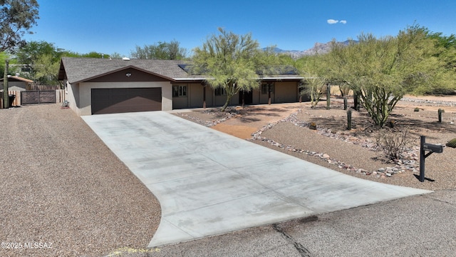 8142 N Modena Dr, Tucson, AZ 85742 - single story home featuring driveway, stucco siding, a garage, a gate, and a mountain view