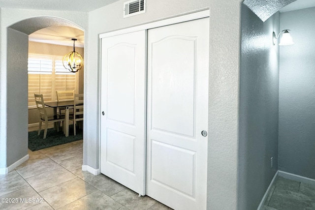 4660 E Torrey Pines Ln, Chandler, AZ 85249 - hall featuring arched walkways, a chandelier, light tile patterned floors, and a textured wall