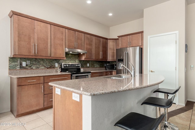 938 E Grass Meadow Pl, Oro Valley, AZ 85755 - kitchen featuring stainless steel appliances, under cabinet range hood, light tile patterned flooring, decorative backsplash, and recessed lighting