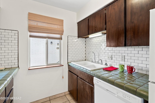 8450 E Old Spanish Trl Apt 154, Tucson, AZ 85710 - kitchen featuring white dishwasher, dark brown cabinetry, tile counters, tasteful backsplash, and light tile patterned floors