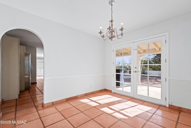 5015 N Via Condesa, Tucson, AZ 85718 - unfurnished dining area featuring french doors, arched walkways, a chandelier, and light tile patterned floors