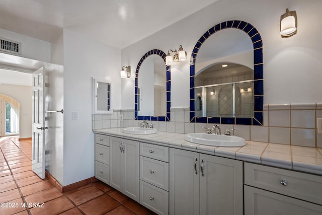 5015 N Via Condesa, Tucson, AZ 85718 - full bathroom featuring decorative backsplash, double vanity, a shower stall, and tile patterned floors