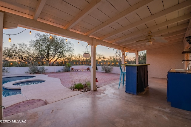 5015 N Via Condesa, Tucson, AZ 85718 - patio terrace at dusk featuring an in-ground hot tub, a patio area, ceiling fan, and a fenced backyard