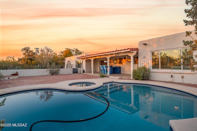 5015 N Via Condesa, Tucson, AZ 85718 - pool at dusk featuring an in-ground hot tub and a patio area