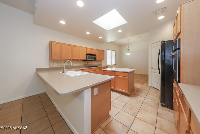 14085 E Copper Mesa Ct, Vail, AZ 85641 - kitchen featuring stainless steel microwave, a skylight, freestanding refrigerator, a center island, and light countertops